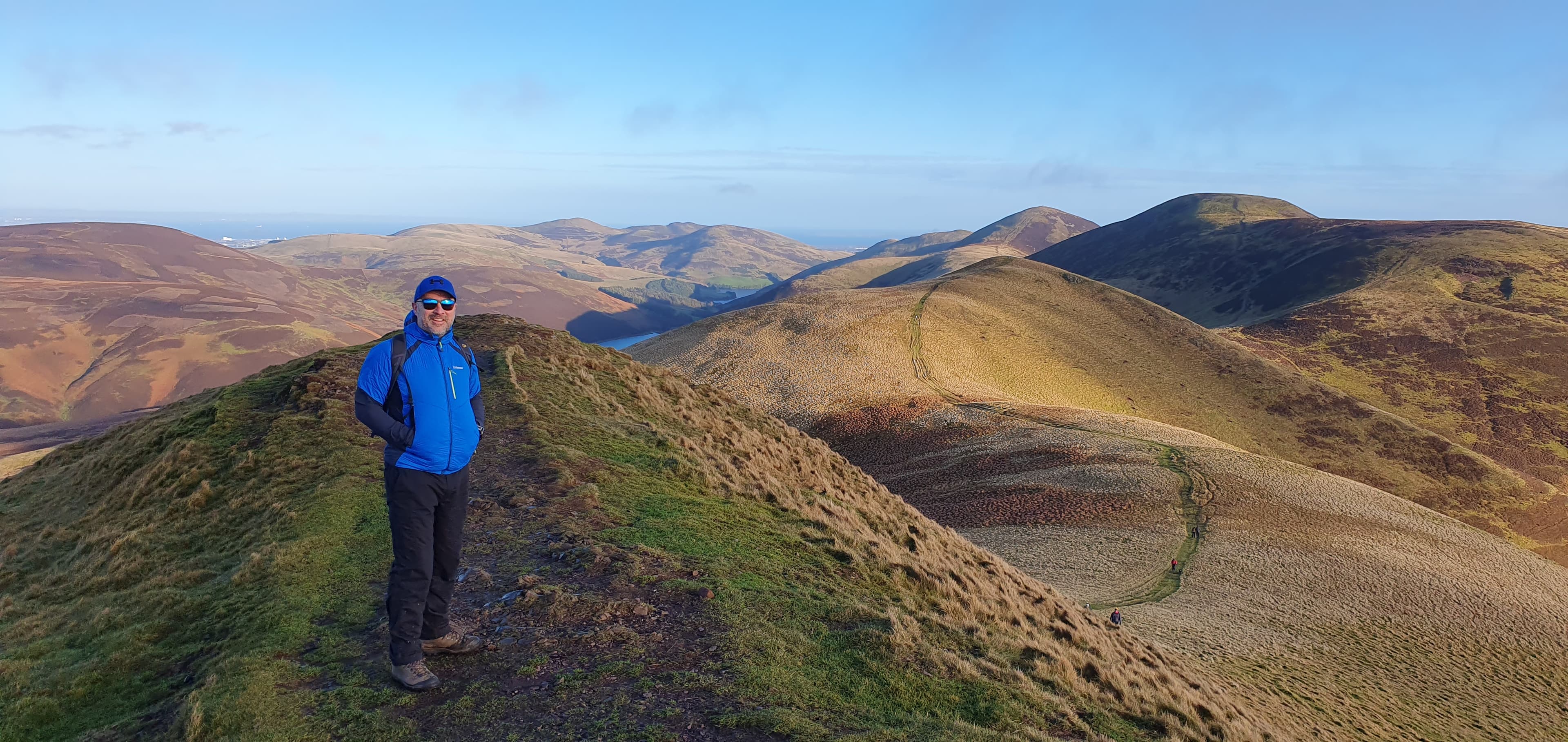 Ross McDowell standing on a Pentland Hills summit near Edinburgh, with open hill views behind him.